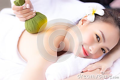 Massager rejuvenate and massage charming beautiful womanâ€™s back by using herbal ball. Attractive girl feels relaxed and happy. Stock Photo